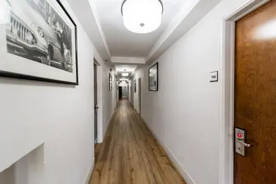 a hallway with white walls and a wooden door at Majestic Hotel South Beach in Miami Beach