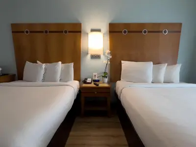 a hotel room with two beds and a table with a lamp at Majestic Hotel South Beach in Miami Beach