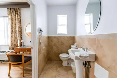 a bathroom with a sink and a toilet and a mirror at Majestic Hotel South Beach in Miami Beach