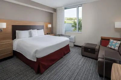 a hotel room with a large bed and a couch at TownePlace Suites Miami Kendall West in Kendall