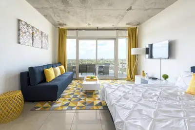 a bedroom with a bed and a couch and a tv at Modern 1 Bedroom Midtown Miami with FREE Parking in Miami