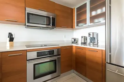 a kitchen with stainless steel appliances and wooden cabinets at Modern 1 Bedroom Midtown Miami with FREE Parking in Miami