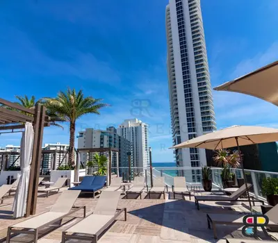 a row of chairs and umbrellas on a balcony with buildings at HYDE Beach House Apartments in Hollywood