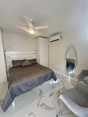 a bedroom with a bed and a ceiling fan at Guayabita's House in Miami