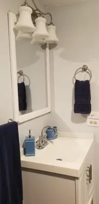 a bathroom sink with a mirror and a blue towel at Guayabita's House in Miami