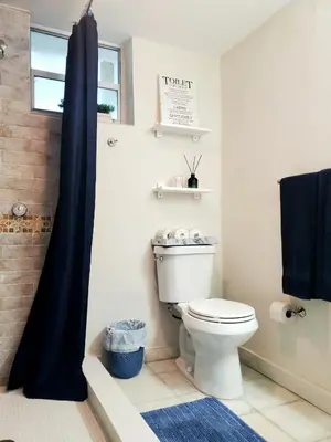 a bathroom with a white toilet and a window at Guayabita's House in Miami