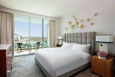 a bedroom with a large white bed and a balcony at The Ritz-Carlton Bal Harbour, Miami in Miami Beach