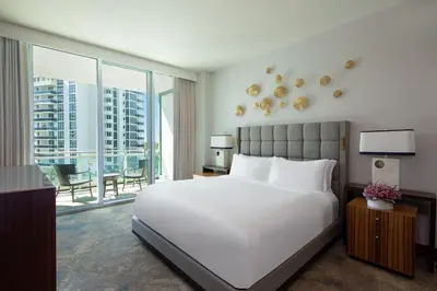 a bedroom with a large white bed and a large window at The Ritz-Carlton Bal Harbour, Miami in Miami Beach