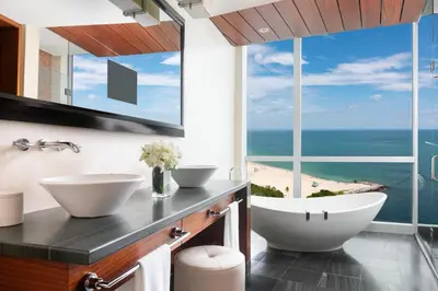a bathroom with two sinks and a view of the ocean at The Ritz-Carlton Bal Harbour, Miami in Miami Beach
