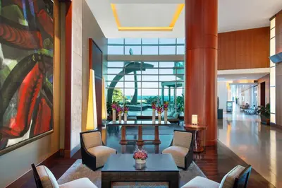 a lobby with chairs and tables in a building at The Ritz-Carlton Bal Harbour, Miami in Miami Beach