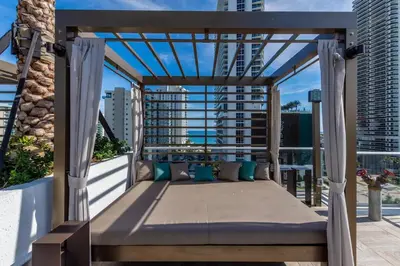 a bed on a balcony with a view of the city at Amazing Apartments at H Beach House in Hollywood