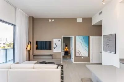 a living room with a white couch and a tv at Amazing Apartments at H Beach House in Hollywood