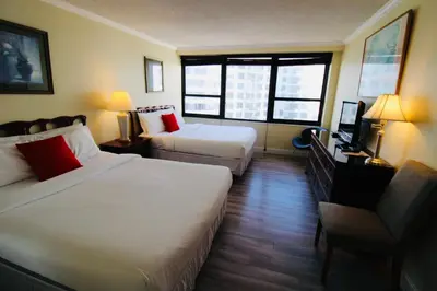 a hotel room with two beds and a television at Alexander 1211 Beachfront Condo with Direct Beach Access, 2 Pools, Sauna, Gym in Miami Beach