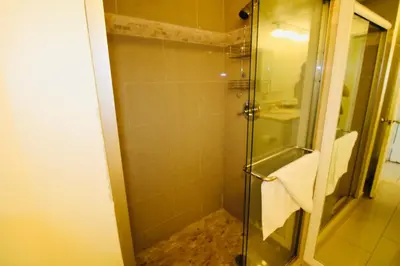 a bathroom with a shower with a glass door at Alexander 1211 Beachfront Condo with Direct Beach Access, 2 Pools, Sauna, Gym in Miami Beach