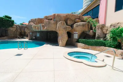 a pool with a rock wall next to a swimming pool at Alexander 1209 Beachfront condo with 2 pools , beach access, sauna, stores in Miami Beach