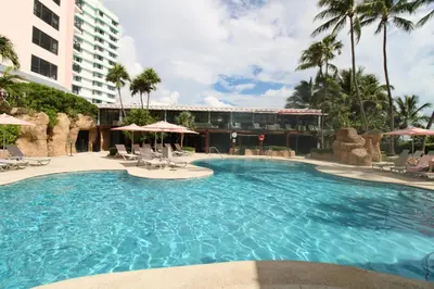a large swimming pool in a resort with palm trees at Alexander 1209 Beachfront condo with 2 pools , beach access, sauna, stores in Miami Beach