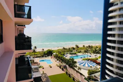 a view of the beach from the balcony of a resort at Alexander 511 Beachfront condo with 2 pools, direct beach access, sauna, tikki bar in Miami Beach