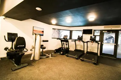 a gym with several treadmills and elliptical machines at Alexander 511 Beachfront condo with 2 pools, direct beach access, sauna, tikki bar in Miami Beach