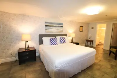 a bedroom with a large white bed with two lamps at Castle M16 Oceanview Loft with Beach access, Pool, Tennis and Free Parking! in Miami Beach