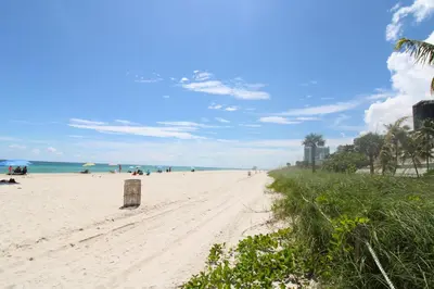 a sandy beach with people on it and the ocean at Castle 922 in Miami Beach