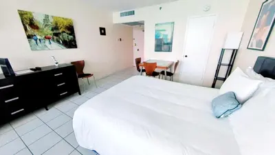 a bedroom with a large white bed and a table at Castle 1033 in Miami Beach