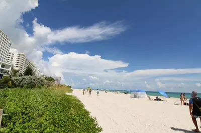 a group of people walking on the beach at Castle 1033 in Miami Beach