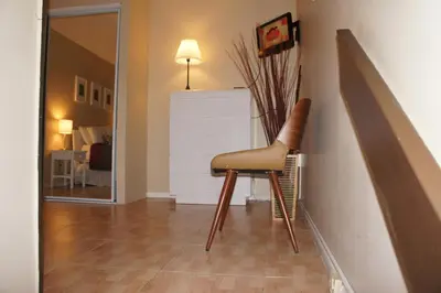 a brown chair sitting in a hallway next to a wall at Castle L1 Double-Loft Condo with Beach Access, Pool, Tennis and Free Parking! in Miami Beach