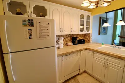 a kitchen with white cabinets and a white refrigerator at Castle L1 Double-Loft Condo with Beach Access, Pool, Tennis and Free Parking! in Miami Beach