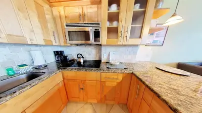 a kitchen with wooden cabinets and a sink at Castle B17 Contemporary Condo with Pool, Beach Access and Free Parking in Miami Beach