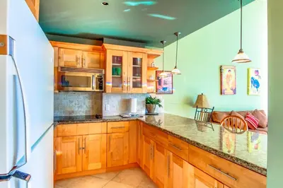 a kitchen with wooden cabinets and a counter top at Castle B17 Contemporary Condo with Pool, Beach Access and Free Parking in Miami Beach