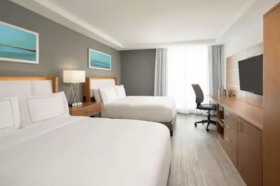 a hotel room with two beds and a desk and a television at DoubleTree by Hilton Miami North I-95 in Miami