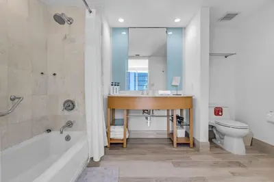 a bathroom with a tub and a sink and a toilet at Steps to the Sand Beachfront Escape- 25th Floor Views in Miami Beach