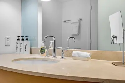 a bathroom with a sink with two faucets at Steps to the Sand Beachfront Escape- 25th Floor Views in Miami Beach