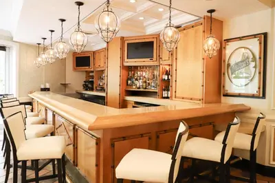 a kitchen with a bar with chairs and lights at Riverside Hotel in Fort Lauderdale