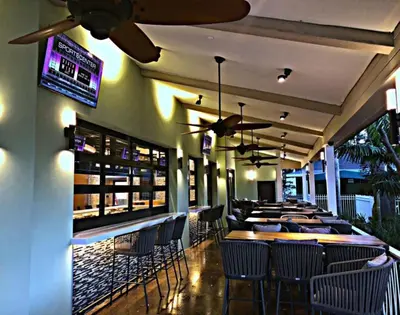 a restaurant with chairs and tables and a bar at Riverside Hotel in Fort Lauderdale