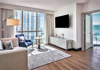 a living room with a couch and a tv at Hyatt Centric Las Olas Fort Lauderdale in Fort Lauderdale