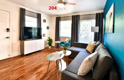 a living room with a couch and a tv at Broadwaysuites Downtown By RocketStay in Miami