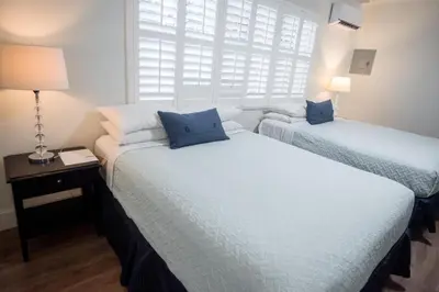 two twin beds in a room with a window at The Drift Hotel in Fort Lauderdale
