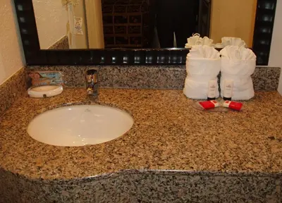 a bathroom counter with a sink and towels on it at Red Carpet Inn Airport Fort Lauderdale in Fort Lauderdale
