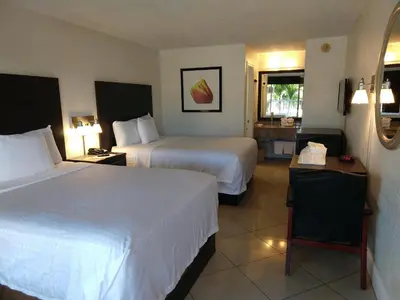 a hotel room with two beds and a window at Red Carpet Inn Airport Fort Lauderdale in Fort Lauderdale