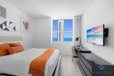 a white bedroom with a bed and a window at Wrap Around Balcony - Insane Views - Amazing Pools in Hollywood