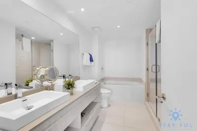 a white bathroom with two sinks and a toilet at Wrap Around Balcony - Insane Views - Amazing Pools in Hollywood
