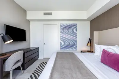 a bedroom with a bed and a desk and a tv at Ocean Breeze Retreat - Pool Gym Access Views in Hallandale Beach