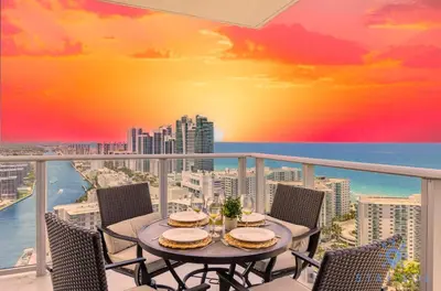 a table on a balcony with a view of the ocean at Luxury 2Br Front Ocean & Bay View, Amazing Pools in Hollywood