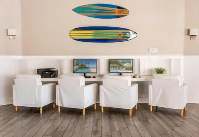 a bar with white chairs and a surfboard on the wall at Palm Tree Club Miami in Miami Beach