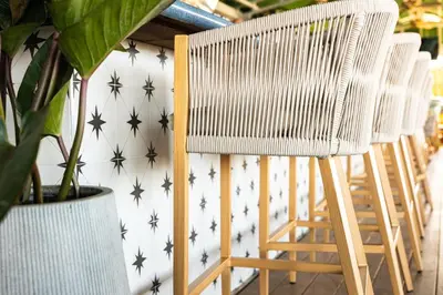 a row of chairs against a wall with black stars at Palm Tree Club Miami in Miami Beach