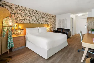 a bedroom with a large white bed and a desk at Palm Tree Club Miami in Miami Beach