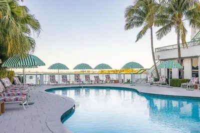 a pool with chairs and palm trees in a resort at Palm Tree Club Miami in Miami Beach
