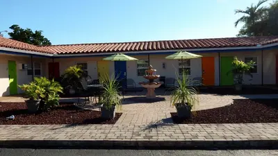 a house with two umbrellas in front of it at Haven Hotel - Fort Lauderdale Airport & Cruise Port in Fort Lauderdale