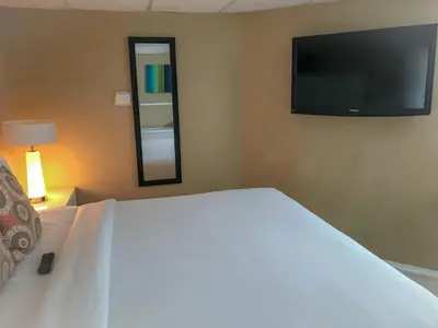a bedroom with a large white bed with a flat screen tv at Haven Hotel - Fort Lauderdale Airport & Cruise Port in Fort Lauderdale